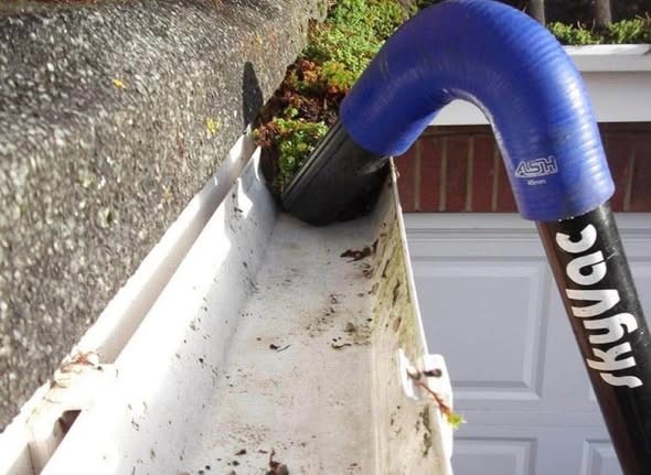 SkyVac gutter vacuum clearing moss from a gutter